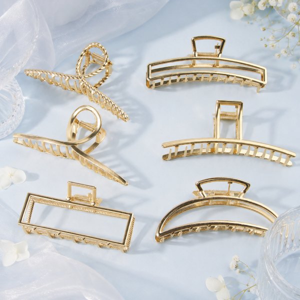 Gold geometric claw clips arranged on a pale blue background