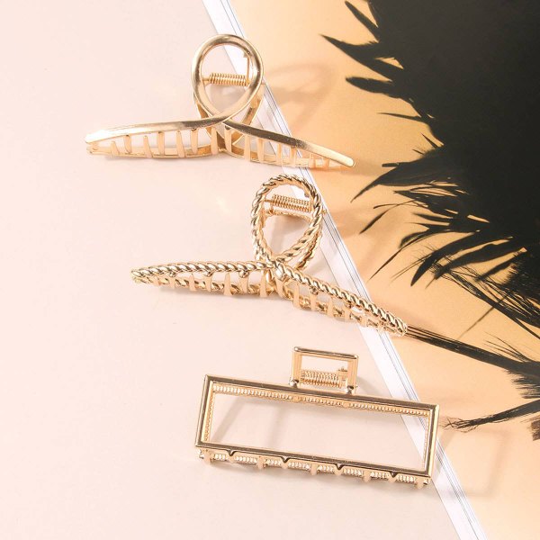 Gold metal claw clips styled on a warm background