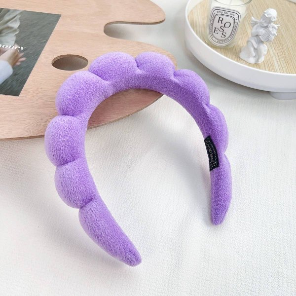Purple plush spa headband on a marble surface